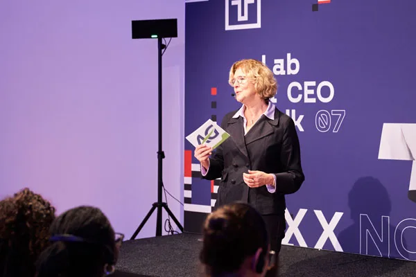 Woman presents on stage during business event.
