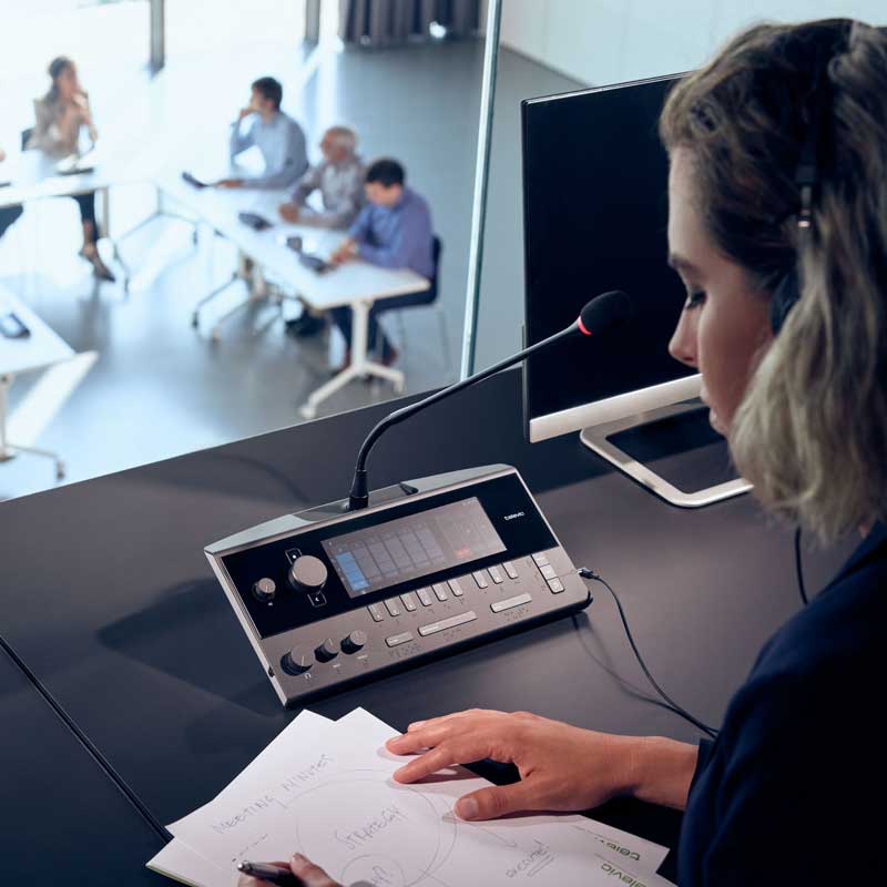 Interpreter speaking into microphone during business meeting